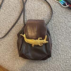 vintage Sasha black leather shoulder bag with a gold alligator closure.